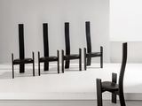 Plusieurs chaises noires sont alignées en rangée dans une pièce blanche