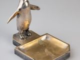 une photo d'une figurine de pingouin posée sur un plateau en métal