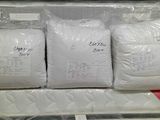 three bags of white pillows sitting on top of each other