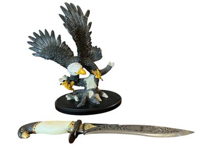 a statue of an eagle and a knife on a table