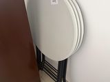 a stack of white plates sitting on a table next to a brown door