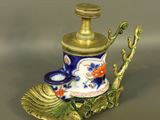 un petit vase bleu et or orné d'une feuille