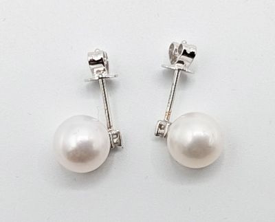 une paire de boucles d'oreilles en perles blanches sur fond blanc