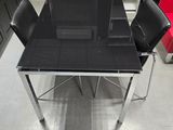 une table en verre entourée de quatre chaises dans une pièce