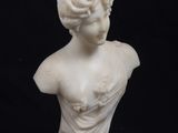 buste en marbre représentant une femme en robe sur fond noir