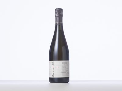 une bouteille de vin posée sur une table blanche