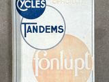 un panneau posé au sol sur lequel est inscrit « tandem » et qui comporte l'image d'un cercle orange et bleu