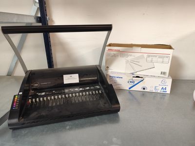 une machine à écrire noire posée sur une table à côté d'une boîte