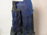 a blue sculpture on a white surface with a white background