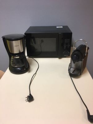 un micro-ondes et une cafetière posés sur une table