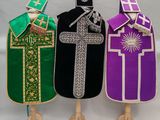 trois robes de couleurs différentes, ornées chacune d'une croix