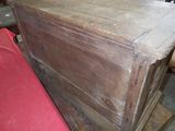 a wooden chest sitting on a red chair in a room