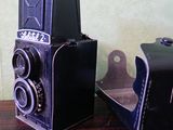 deux vieux appareils photo posés l'un à côté de l'autre sur une table