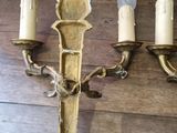 three wall sconces that are attached to a wooden wall