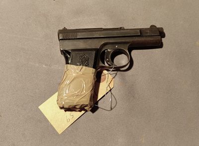 a gun that is sitting on a table with a tag on it