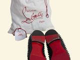 pair of red shoes in a white bag with a red sole