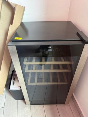 a wine cooler that is sitting on the floor next to a box