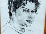 portrait of a young man in a wood frame with a pencil drawing of him