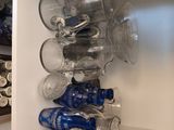 Des bouteilles et des verres sont empilés sur une étagère dans une cuisine.