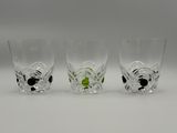 three shot glasses with black and white designs on them