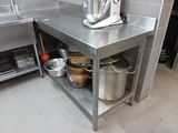 stainless steel counter with pots and pans on it in a commercial kitchen