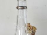 a small glass bottle with a gold lid on a table