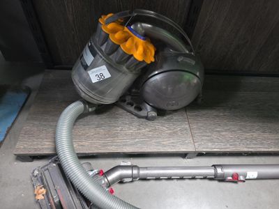 un aspirateur posé sur le sol à côté d'un tuyau