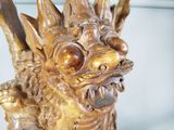 a golden dragon statue on display in a glass case