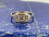une image représentant une bague en diamant posée sur une pierre bleue