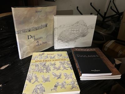 Plusieurs livres sont posés sur une table recouverte d'une nappe noire.