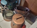 de nombreuses casseroles et poêles posées par terre dans la cuisine