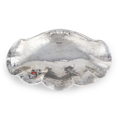 une assiette en argent ornée d'une coccinelle
