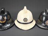 three firemen hats are lined up against a black background