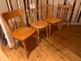 four wooden chairs sitting in a row on the floor