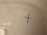 a white bowl with a blue cross on it