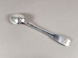 une cuillère en argent avec un manche de cuillère sur une table