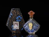 two bottles of perfume sitting next to each other on a black surface