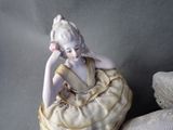 a figurine of a woman sitting on a pillow