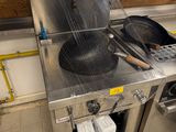 stainless steel counter top with pots and pans on it in a commercial kitchen