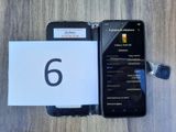 a cell phone that is sitting next to a notepad