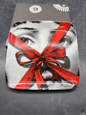 une assiette sur laquelle est représentée une femme entourée d'un ruban rouge