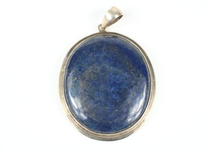 un gros plan d'un pendentif en pierre bleue sur fond blanc