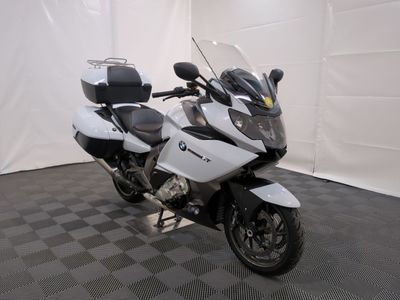 une moto blanche garée dans une pièce au sol en damier