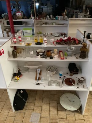 une étagère blanche sur laquelle sont posés de nombreux objets, dans la cuisine