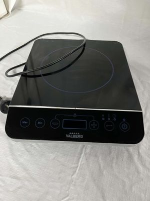an image of a black electric cooktop with a cord plugged into it