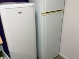 two refrigerators next to each other in a room