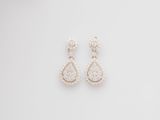 a pair of diamond earrings on a white background