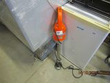an orange cord attached to the side of a refrigerator