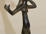 bronze statue of a woman holding a cell phone to her ear