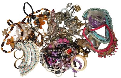a pile of assorted bracelets on a white surface
